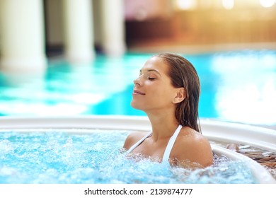 Warming Up The Hot Tub. Shot Of A Young Woman Relaxing At A Spa Pool.