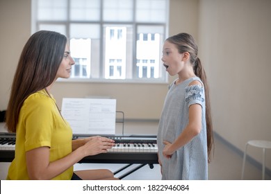 Warming Up. Girl In A Blue Dress Having A Vocal Lesson