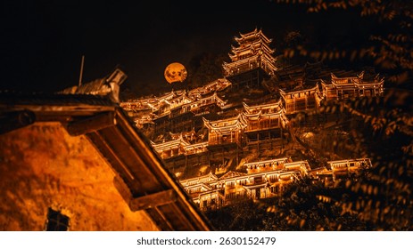 Calle comercial tradicional china calurosamente iluminada por la noche en la ciudad del valle de Wangxian, con edificios de madera, faroles y un ambiente acogedor bajo un árbol Grande.