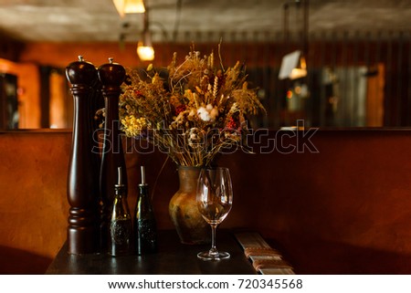 Warmth image with a dry flowers bouquet over an orange wall