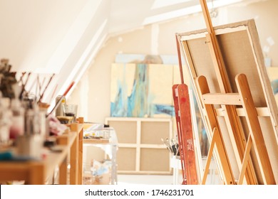 Warm-toned Background Image Of Empty Art Studio Interior Lit By Sunlight, Focus On Easel In Foreground, Copy Space
