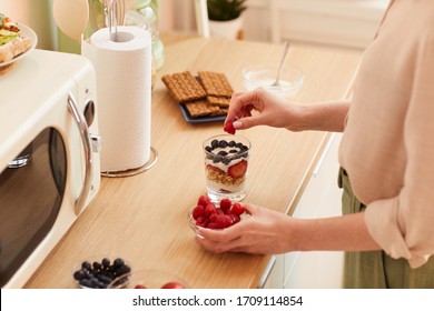 Warm-toned Close Up Of Unrecognizable Young Woman Making Yogurt Parfait With Fresh Berries And Granola While Preparing Healthy Breakfast In Morning, Copy Space