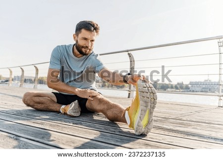 Warm-up active for running for active training, a young guy is an athlete. A man stretching his body outdoors taking care of his health.