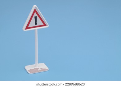 Warning about dangers road sign on blue background. Copy space for text. - Shutterstock ID 2289688623