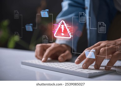 Warning alert icon with a hacked document system.Hands typing on a keyboard with a red cybersecurity threat alert, surrounded by digital files and documents.