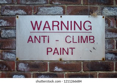 warning for anti climb paint on a red brick wall background taken outside in London 