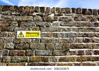 'Warning anti climb paint' sign on the wall of a public park