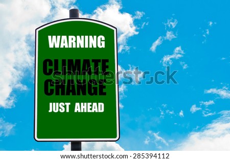Warning Climate Change Just Ahead written on green road sign  against clear blue sky background. Concept image with available copy space