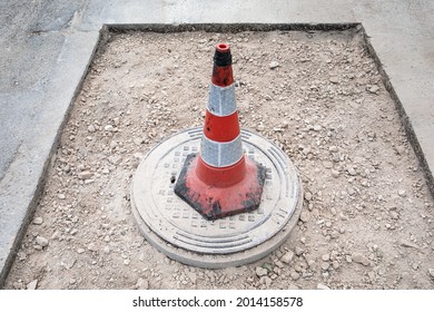 Warning Cone With Reflectors. Asphalt Road Repair And Sewerage Well.