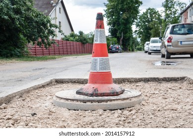 Warning Cone With Reflectors. Road Repair And Sewerage Well.