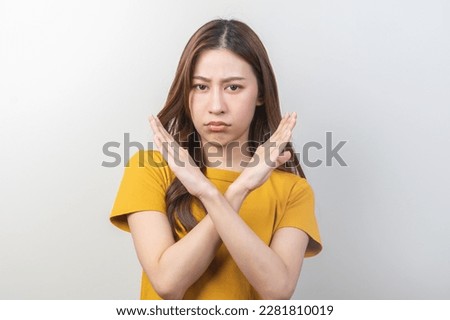 Warning expression negative and serious on face. Asian young woman, female stand making stop, showing gesture hands, doing symbol deny with palm isolated on background at home, perspective forbidden.