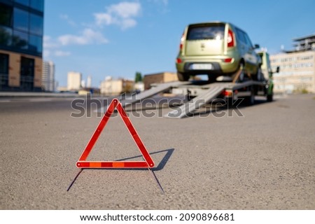Warning foldable triangle placed before tow track