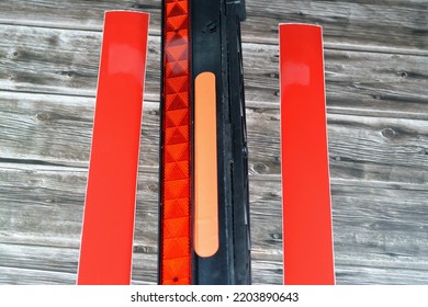 A Warning Foldaway Reflective Road Hazard Warning Triangle And A Pair Of Car Phosphorescent Reflective Stickers Isolated On Wooden Background, Selective Focus Of Transportation Safety And Road Repair