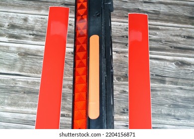 A Warning Foldaway Reflective Road Hazard Warning Triangle And A Pair Of Car Phosphorescent Reflective Stickers Isolated On Wooden Background, Selective Focus Of Transportation Safety And Road Repair