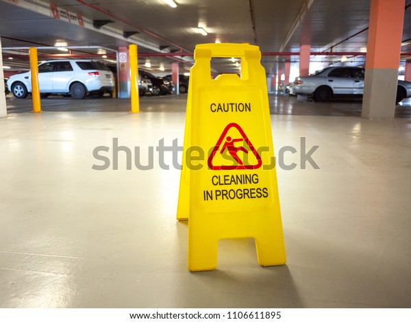 Warning janitorial sign of cleaning\
in progress in car park to warn passersby for\
safety.