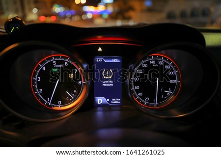 Warning lights flash on car dashboard. Low tire pressure error sign.