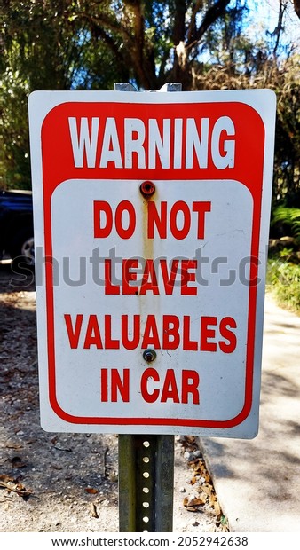 Warning parking metal sign Do\
Not Leave Valuables In Car. Parking lot metal sign red and white\
Warning.