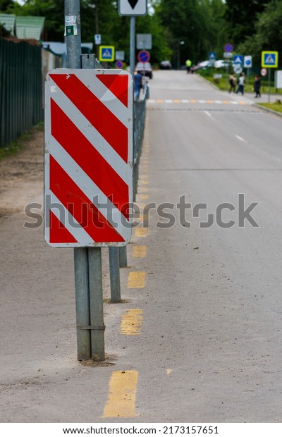 warning red and\
white diagonal striped vertical marking 8.22.2 sign at the end of\
road fence, separating road\
and