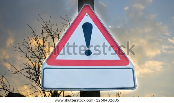 Warning road sign with an exclamation mark icon\
for high speed alert. Attention or danger sign. Warning symbol in\
red triangle on sunset sky. Traffic signal to drivers. Safety first\
driving concept.