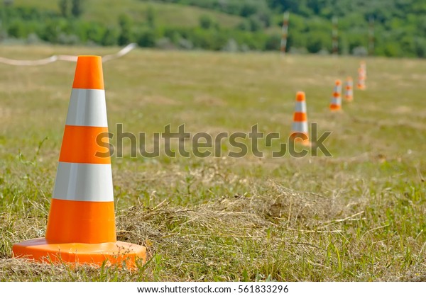Warning road sign traffic cone classical\
form with reflective orange and white\
stripes