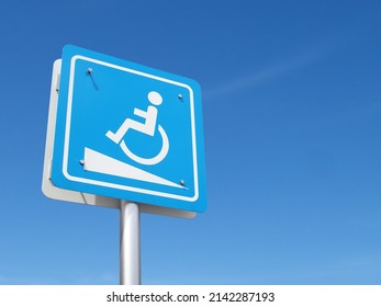 warning sign be careful of ramp floor for disabled, white handicapped symbol sitting on wheelchair going up ramp on blue metal sign with clear sky background, hospital service for patients admitted
