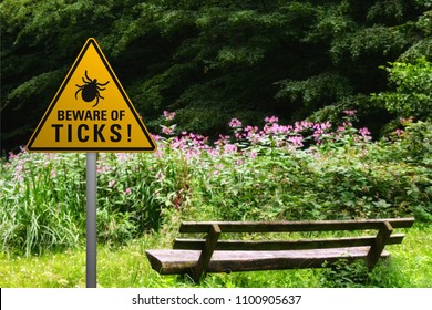 Warnschild "Vorsicht vor Zecken" auf einer Bank im Naturpark