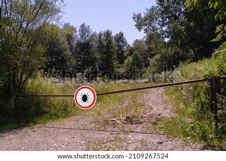 Warning sign beware of ticks in infested area in the forest.