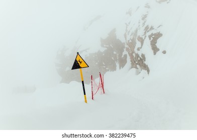 Warning sign in the mountains for skiers and snowboarders during heavy snowfall - Shutterstock ID 382239475