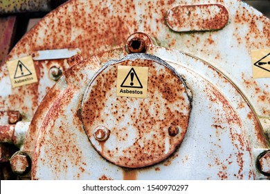 Warning sign on an industrial valve with exclamation mark and Asbestos. Asbestos is a term used to refer to six naturally occurring silicate minerals and still kills around 5000 workers each year.
