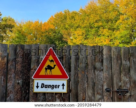 warning sign on a wooden fence in the zoo garden