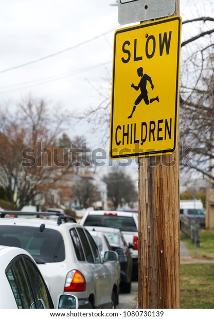 warning\
sign post on street pole to slow for\
children