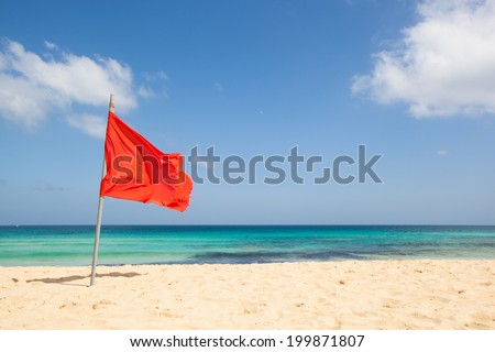 warning sign of a red flag at a beautiful beach with a blue sky and a turquoise sea, Fuerteventura, Canary Islands, Spain, Europe