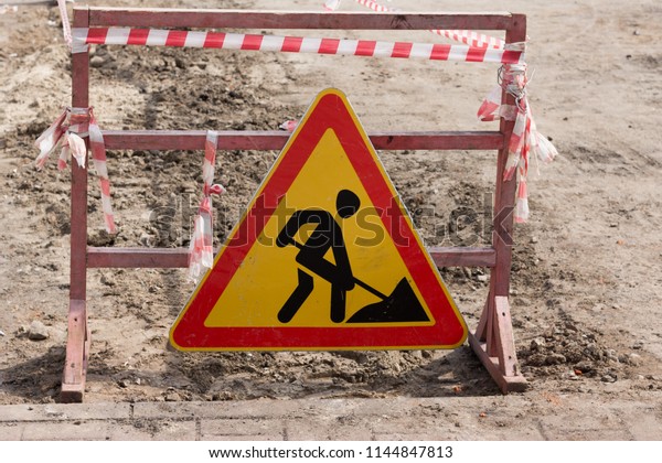 Warning sign road works.\
Road repair.