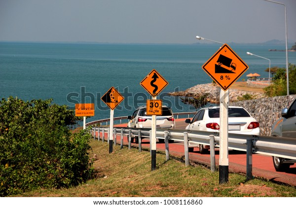 Warning sign, steep road, curving way and watch\
out for falling rocks.