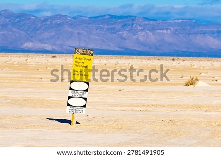 Warning sign for unexploded munitions with keep out message in a desert environment