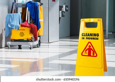 The Warning Signs Cleaning In Process The Floor Of The Building And Janitorial Car Parked In Back To Prevent Corona Virus Covid-19 Infection.