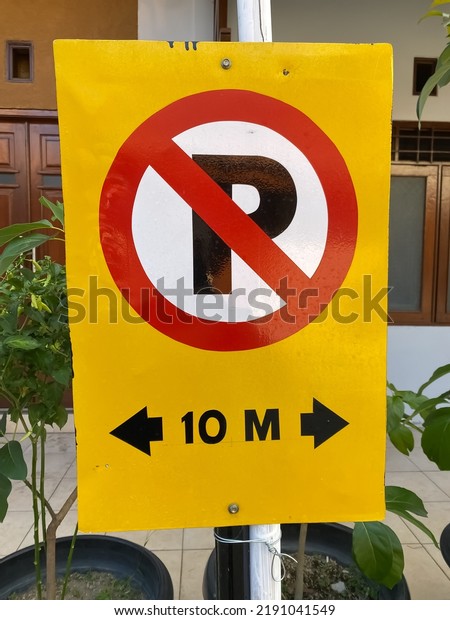 Warning signs are prohibited
from parking in a radius of 10 meters around here.  The board is
yellow.