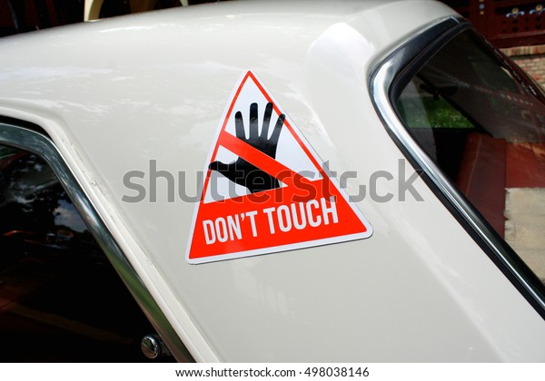 warning sticker\
with text Don\'t touch on old\
car