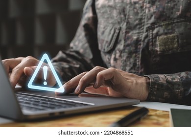 Warning system problem should be careful, Prevent data leaks and maintenance system concept, Soldier in camouflage uniform working on laptop with warning icon.