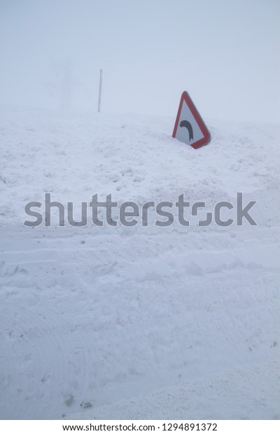 Warning traffic sign\
burried under the snow 