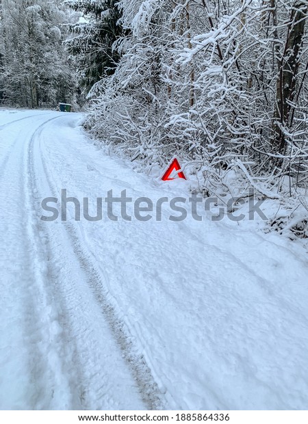Warning triangle, car breakdown in winter on a\
snowy road in Sweden