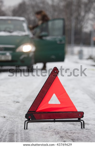 warning\
triangle in foreground and car on\
background