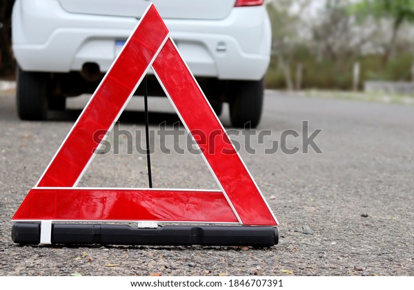 Warning triangle, red triangle with car in\
the background. Red emergency stop sign.\
