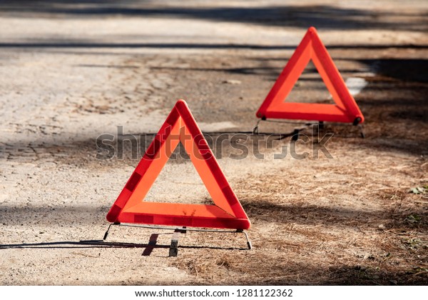 Warning triangles at\
hill road on mountain in the forest, damaged road. Misty road, bad\
weather driving.