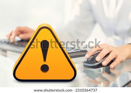 Warning yellow sign on table with computer
