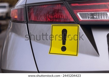 Warning yellow sticker with exclamation sign. Car driver newbie concept