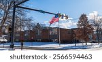 Warren, Pennsylvania, USA December 22, 2024 An intersection with red lights and an American flag on Market Street on a sunny, snowy winter day