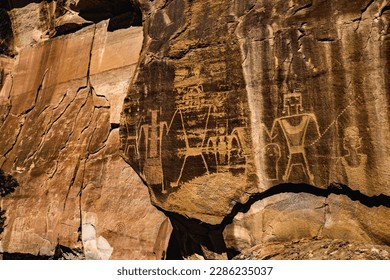 Warrior figures stand holding a severed head - part of the Mcconkie ranch petroglyphs created by the ancient Fremont culture, and located near the town of Vernal in northeastern Utah, United States.