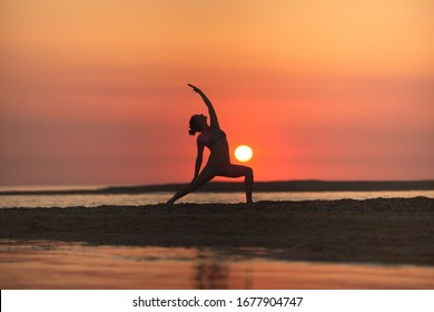 Warrior Pose From Yoga By Woman Silhouette On Sunset