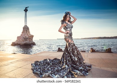 Warrior woman. Fantasy fashion idea. beautiful girl in armor. Portrait of a beautiful lady warrior, dark-haired girl in a gray dress. Monument to the Scuttled Ships, Sevastopol, Crimea - Shutterstock ID 569182261